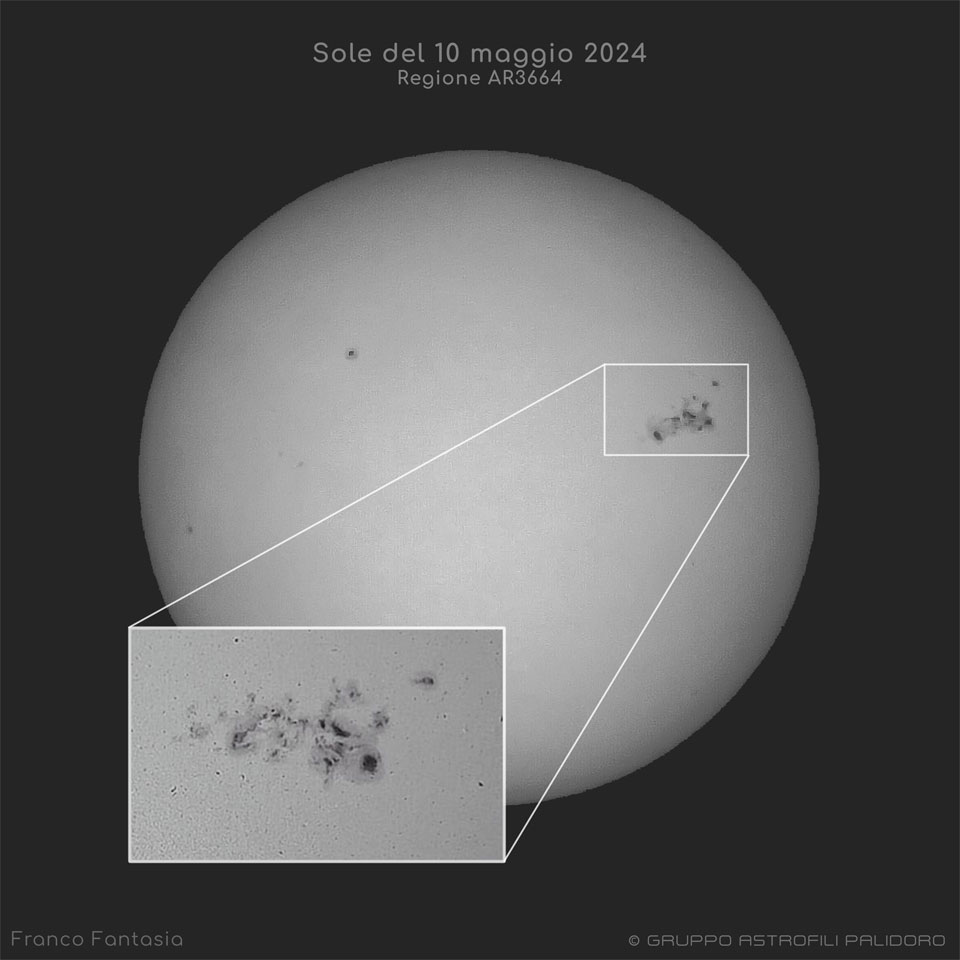 太阳以黑白两色显示，在最右边是黑色的太阳黑子。大的太阳黑子群在左下角的嵌入图像中展开。有关更多详细信息，请参阅说明。