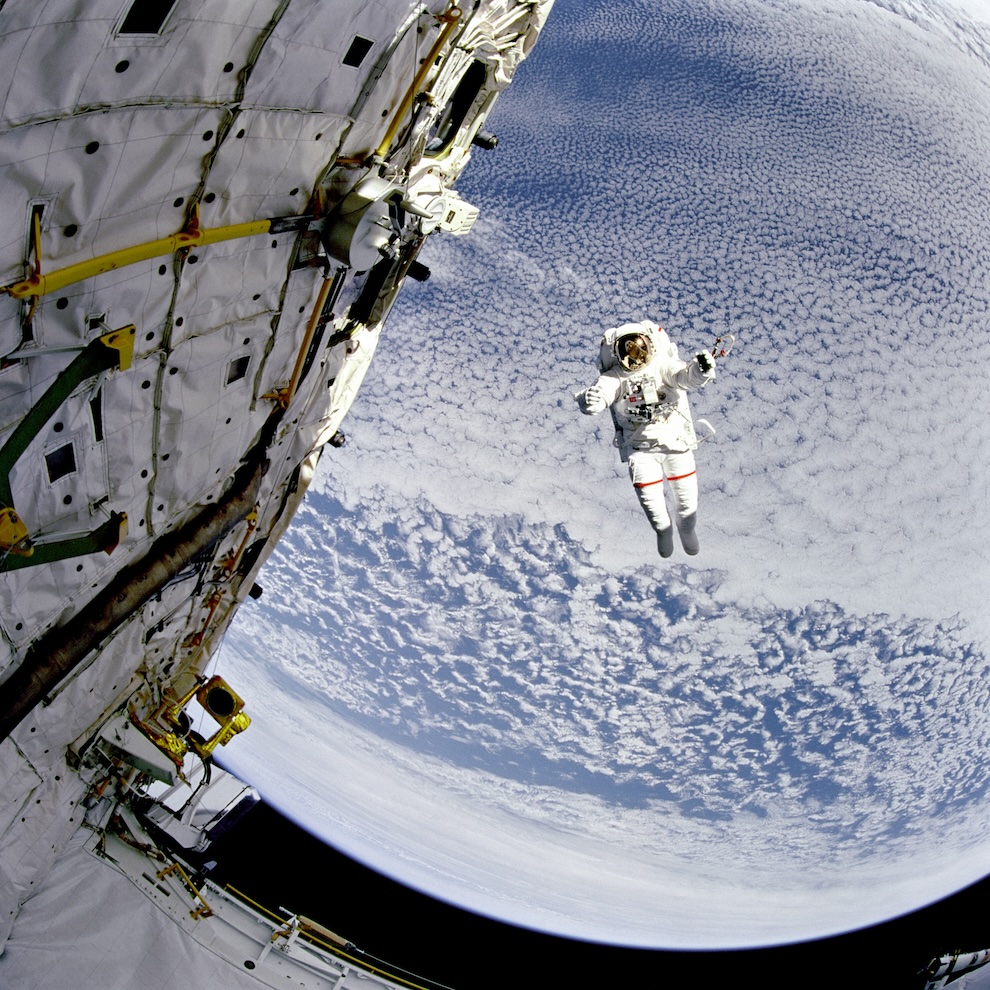 Backdropped against the blue and white Earth 130 nautical miles below, astronaut Mark C. Lee tests the new Simplified Aid for EVA Rescue (SAFER) system.